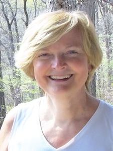 Here's an alt tag for the image: Smiling woman with short blond hair.
